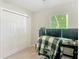 This carpeted bedroom features a window, a ceiling fan, a closet, and an office setup with two monitors on a desk at 5092 Sw 197Th Ter, Dunnellon, FL 34431