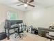 This carpeted bedroom has a ceiling fan, a window, and an office setup with two monitors on a desk at 5092 Sw 197Th Ter, Dunnellon, FL 34431