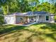 Charming home exterior showcasing a well-maintained lawn, quaint porch with seating, and a two-car garage at 5092 Sw 197Th Ter, Dunnellon, FL 34431