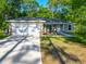Charming single-story home featuring a two-car garage and a welcoming front porch with rocking chairs at 5092 Sw 197Th Ter, Dunnellon, FL 34431