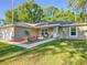 Front view of home with a tidy landscape, walkway, porch, rocking chairs and fresh white trim at 5092 Sw 197Th Ter, Dunnellon, FL 34431