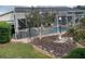 Serene backyard showcasing a screened-in pool with stone details, offering a relaxing oasis at 6512 Sw 60Th Ct, Ocala, FL 34474