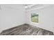 Bright bedroom features wood flooring and a window with a green backyard view at 6776 Sw 151St Loop, Ocala, FL 34473