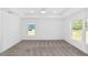 Bright main bedroom with plush carpet, tray ceiling, and large windows allowing for natural light at 6776 Sw 151St Loop, Ocala, FL 34473