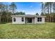 Exterior shot of the back of the home with a large yard and a covered patio area for outdoor entertaining at 7030 Sw 128Th St, Ocala, FL 34473