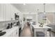 Modern kitchen with white cabinets, an island with seating, and stainless steel appliances, connecting to the dining area at 7030 Sw 128Th St, Ocala, FL 34473