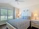 Comfortable bedroom with a ceiling fan, a large window, and blue floral bedding at 779 Oldsmar Ter, The Villages, FL 32163