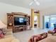 Open living room boasts a large entertainment center and sliding glass doors to the patio at 779 Oldsmar Ter, The Villages, FL 32163