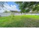 View of the home's backyard featuring lush green grass and a well-maintained white picket fence at 9 Fir Trail Pass, Ocala, FL 34472
