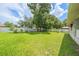 A lush backyard with green grass is surrounded by a white fence, offering a private outdoor space at 9 Fir Trail Pass, Ocala, FL 34472