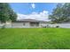 A spacious backyard featuring lush green grass, a white picket fence, and a covered patio at 9 Fir Trail Pass, Ocala, FL 34472