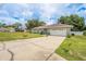 Charming home exterior with a spacious driveway and well-manicured lawn, perfect for outdoor activities at 9 Fir Trail Pass, Ocala, FL 34472