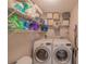 Functional laundry room with shelving, storage bins, and modern washer and dryer units for efficient chore management at 9 Fir Trail Pass, Ocala, FL 34472