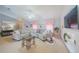 Spacious living room featuring an L-shaped couch, modern TV, recessed lighting, and neutral decor at 9 Fir Trail Pass, Ocala, FL 34472