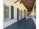 Exterior balcony has black railings, green shutters, and a wood-paneled ceiling at 950 Sw 43Rd Pl, Ocala, FL 34471