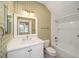 Nicely decorated bathroom with vanity, mirror, shower and tub combo, and patterned wallpaper at 950 Sw 43Rd Pl, Ocala, FL 34471