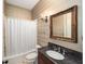 Cozy bathroom featuring a shower and tub combo, vanity with granite countertop, and decorative mirror at 950 Sw 43Rd Pl, Ocala, FL 34471