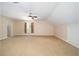 Large carpeted bedroom features a window, curtains, a ceiling fan, and two doors at 950 Sw 43Rd Pl, Ocala, FL 34471
