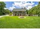 Sprawling two-story home with a large front lawn, circular fountain, and lush greenery at 950 Sw 43Rd Pl, Ocala, FL 34471