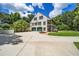 Exterior view of home with three-car garage, driveway, and mature landscaping at 950 Sw 43Rd Pl, Ocala, FL 34471