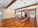 Open-concept living room with wood beams, hardwood floors, and a brick fireplace feature at 950 Sw 43Rd Pl, Ocala, FL 34471