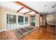 Bright living room features wood beams, hardwood floors, and large windows overlooking the pool at 950 Sw 43Rd Pl, Ocala, FL 34471