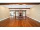 Spacious living room with exposed wood beams, hardwood floors, and a brick fireplace at 950 Sw 43Rd Pl, Ocala, FL 34471
