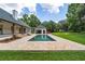 Backyard pool surrounded by brickwork and lush green grass at 950 Sw 43Rd Pl, Ocala, FL 34471