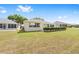 A well-manicured backyard with a green lawn, shrubs, and other single story homes nearby at 9693 Sw 90Th St, Ocala, FL 34481