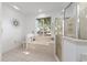 Bright bathroom featuring a soaking tub under a window and glass-enclosed shower at 9693 Sw 90Th St, Ocala, FL 34481
