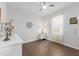 A simple bedroom, showcasing neutral tones, wood floors, and a ceiling fan at 9693 Sw 90Th St, Ocala, FL 34481