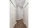 Hallway featuring multiple closet doors and wood flooring at 9693 Sw 90Th St, Ocala, FL 34481