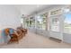 Bright sunroom featuring wicker furniture, carpet flooring, and multiple windows with scenic views at 9693 Sw 90Th St, Ocala, FL 34481