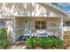 Inviting front porch featuring a white wicker bench with blue cushions and well-maintained landscaping at 9726 Sw 94Th Ter # C, Ocala, FL 34481