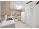 Well-lit kitchen featuring light wood cabinets, white appliances, tile flooring, and a double basin sink at 9758 Sw 94Th Ave # A, Ocala, FL 34481