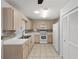 Bright kitchen with light wood cabinetry, tile flooring, white appliances, and neutral backsplash at 9758 Sw 94Th Ave # A, Ocala, FL 34481