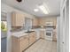 Open kitchen design with light wood cabinets, white appliances, and a breakfast bar overlooking the living area at 9758 Sw 94Th Ave # A, Ocala, FL 34481