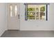 Bright living room featuring a decorative front door and a window with neighborhood views at 9758 Sw 94Th Ave # A, Ocala, FL 34481