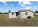 Back of the home with partial view of the yard and utilities equipment at 10197 Sw 88Th Ter, Ocala, FL 34481