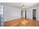 Bedroom featuring hardwood floors, ceiling fan and an entrance to hallway at 10197 Sw 88Th Ter, Ocala, FL 34481