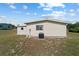 Well-maintained beige home with a modern air conditioner and lush green lawn at 10197 Sw 88Th Ter, Ocala, FL 34481