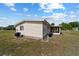 Beige home featuring a screened lanai, complemented by a neatly maintained lawn at 10197 Sw 88Th Ter, Ocala, FL 34481
