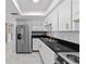 Modern kitchen with stainless steel appliances, sleek black countertops, and stylish white cabinets with gold handles at 10197 Sw 88Th Ter, Ocala, FL 34481
