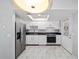 Modern kitchen boasts stainless steel appliances, sleek black countertops, stylish white cabinets, and marble floors at 10197 Sw 88Th Ter, Ocala, FL 34481