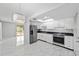 Modern kitchen featuring stainless steel appliances, white cabinets, and a stylish dining area with marble floors at 10197 Sw 88Th Ter, Ocala, FL 34481