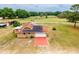 Aerial of property with large fenced in pasture, outbuildings and solar panels on house at 10631 W Highway 40, Ocala, FL 34482