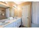Bright bathroom with double sinks, tiled flooring, large mirrors and a shower/tub combo at 10631 W Highway 40, Ocala, FL 34482