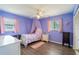 Charming bedroom with wood floor, large window, purple walls, and unicorn decorations at 10631 W Highway 40, Ocala, FL 34482