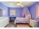 Cute bedroom features wood floor, purple walls, a canopy bed, and ceiling fan at 10631 W Highway 40, Ocala, FL 34482
