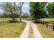 Rural driveway leading to property amidst verdant landscape at 10631 W Highway 40, Ocala, FL 34482
